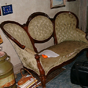 Loveseat before restoration — original fabric removed and frame exposed